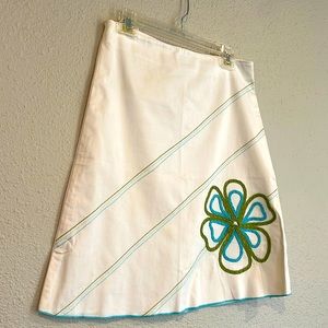 Whit cotton skirt with teal and green cording detail in a flower.